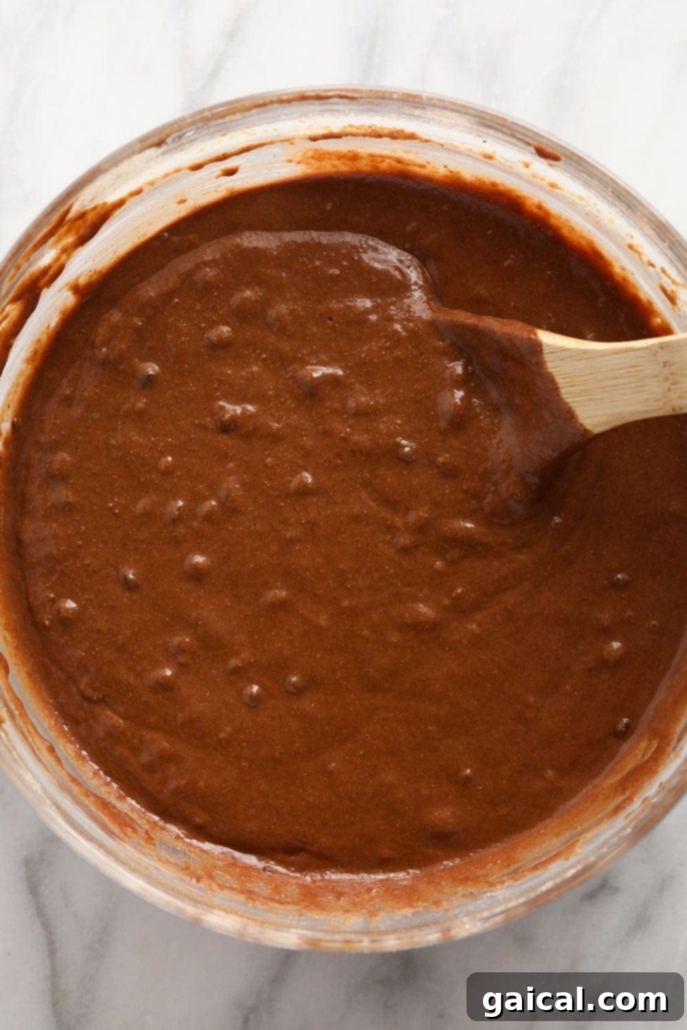 Incredibly moist healthy chocolate peanut butter muffins are made with whole wheat flour, naturally sweetened with coconut sugar and maple syrup, and flavored with all-natural peanut butter! Thick, rich chocolate peanut butter muffin batter in a large mixing bowl, ready to be scooped into a muffin tin.