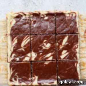 Finished and chilled cheesecake bars with a perfectly set white and chocolate swirl, ready for serving.