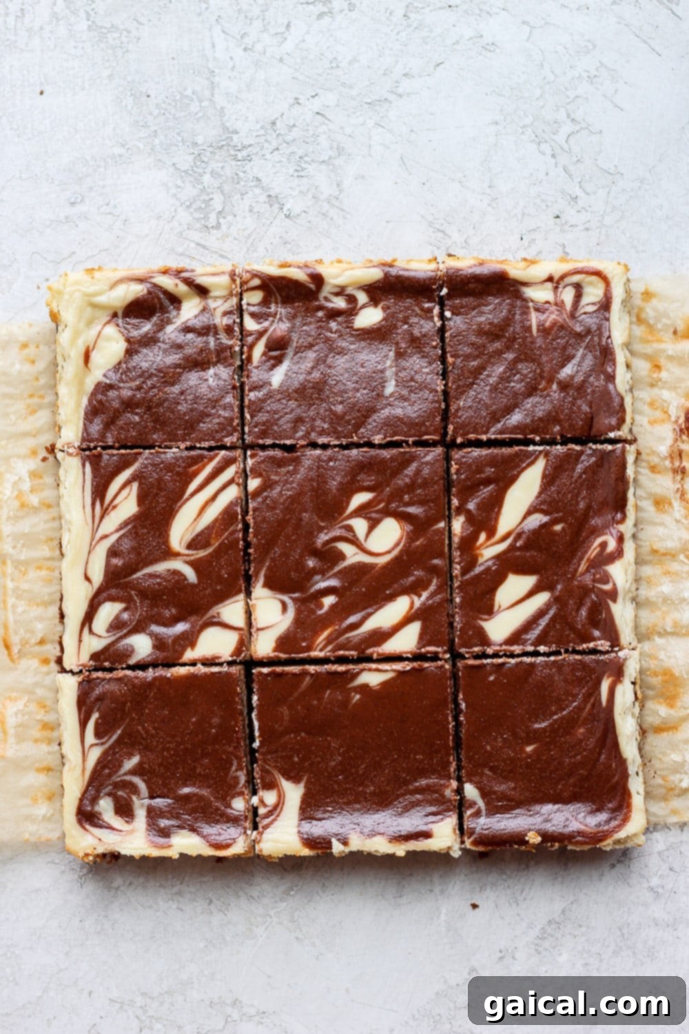 Perfectly sliced Greek yogurt cheesecake bars, showcasing the uniform chocolate chai swirl and golden crust.
