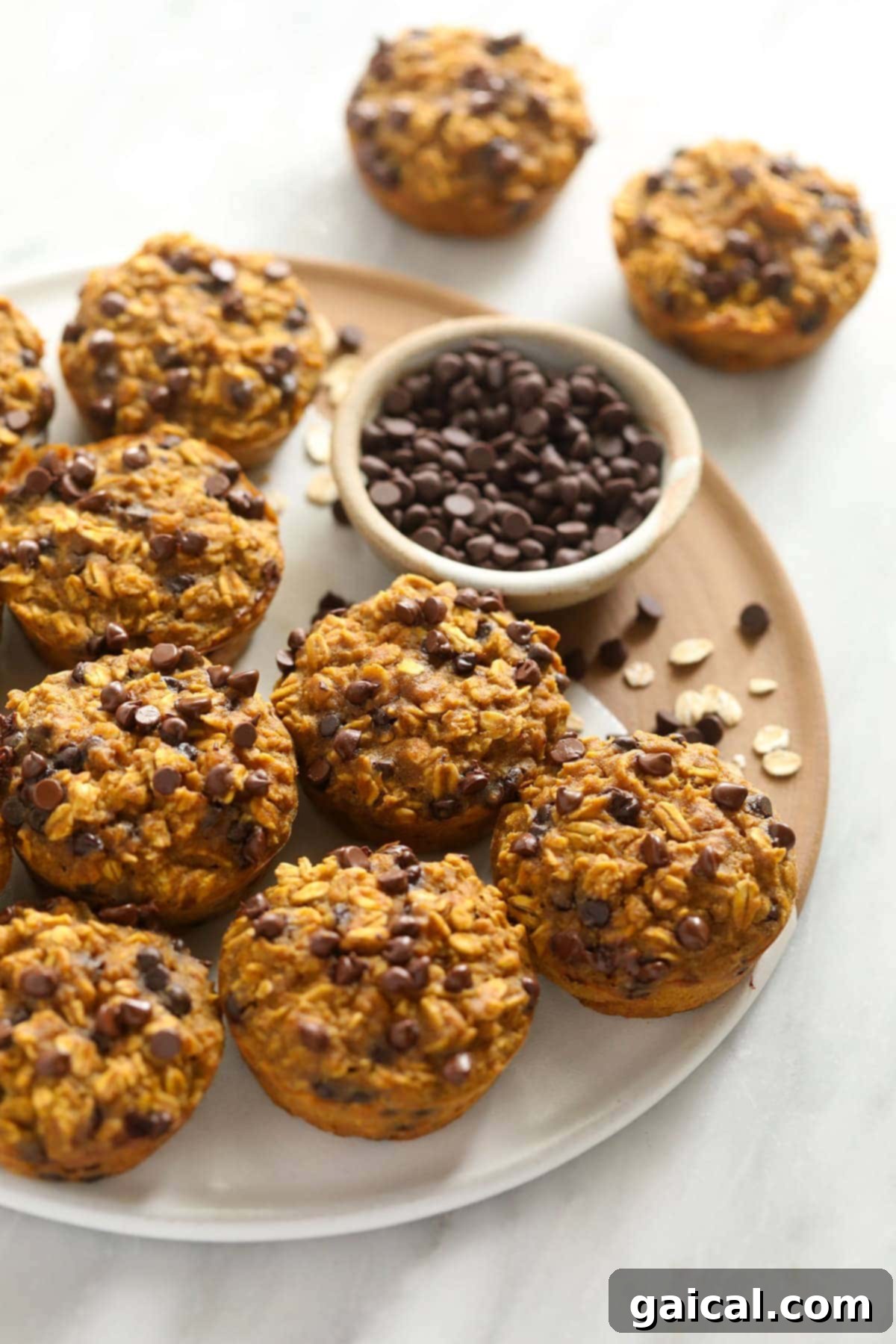 Spiced Pumpkin Oat Cups 5 Close-up of freshly baked pumpkin oatmeal cups with mini chocolate chips on a baking tray, highlighting their tempting texture.