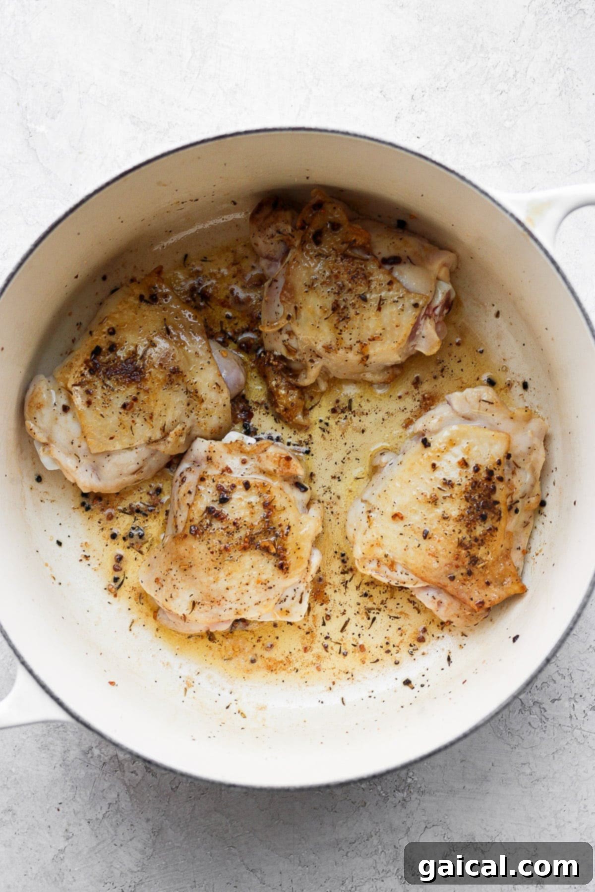 A flavorful chicken and rice recipe made with juicy chicken thighs and the most flavorful rice medley you've ever had! And, yes, it includes tons of veggies! Sautéed, golden-brown chicken thighs in a Dutch oven, ready for baking.
