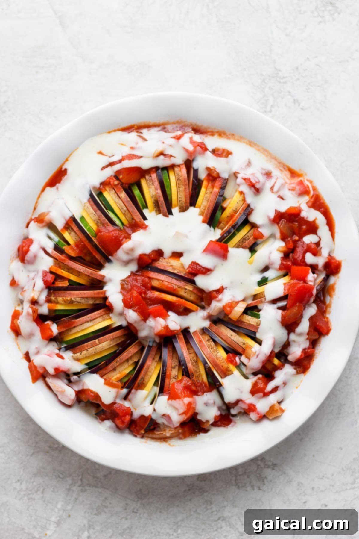 Baked ratatouille garnished with fresh basil and goat cheese, ready to be served.