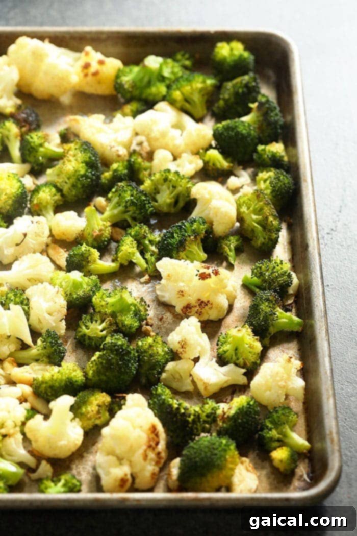 Cheesy Broccoli Cauliflower Delight 3 Roasted cauliflower and broccoli florets on a baking sheet, golden and tender.