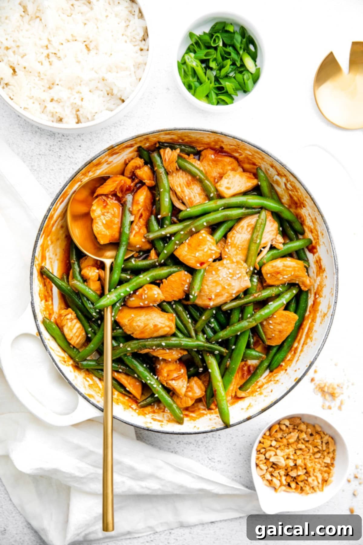 Ready to Serve: Delicious Kung Pao Chicken Stir Fry A large skillet filled with cooked Kung Pao Chicken, green beans, and sauce, garnished generously with sesame seeds