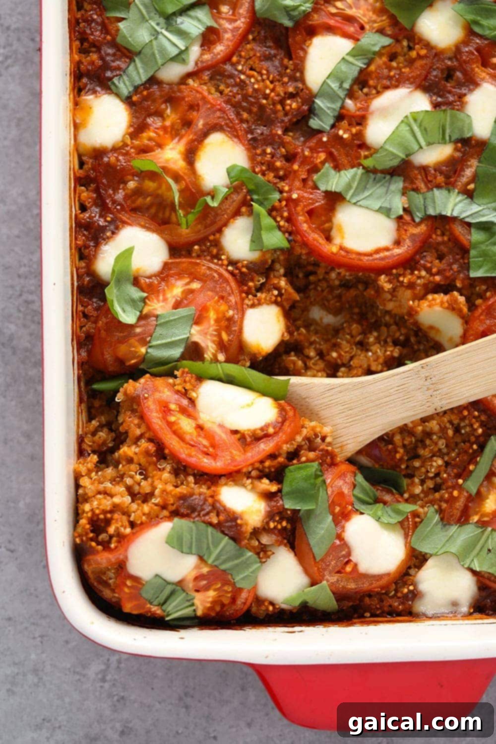 Tuscan chicken quinoa casserole with vibrant tomatoes, creamy mozzarella, and fresh green basil leaves on top, ready to be served.