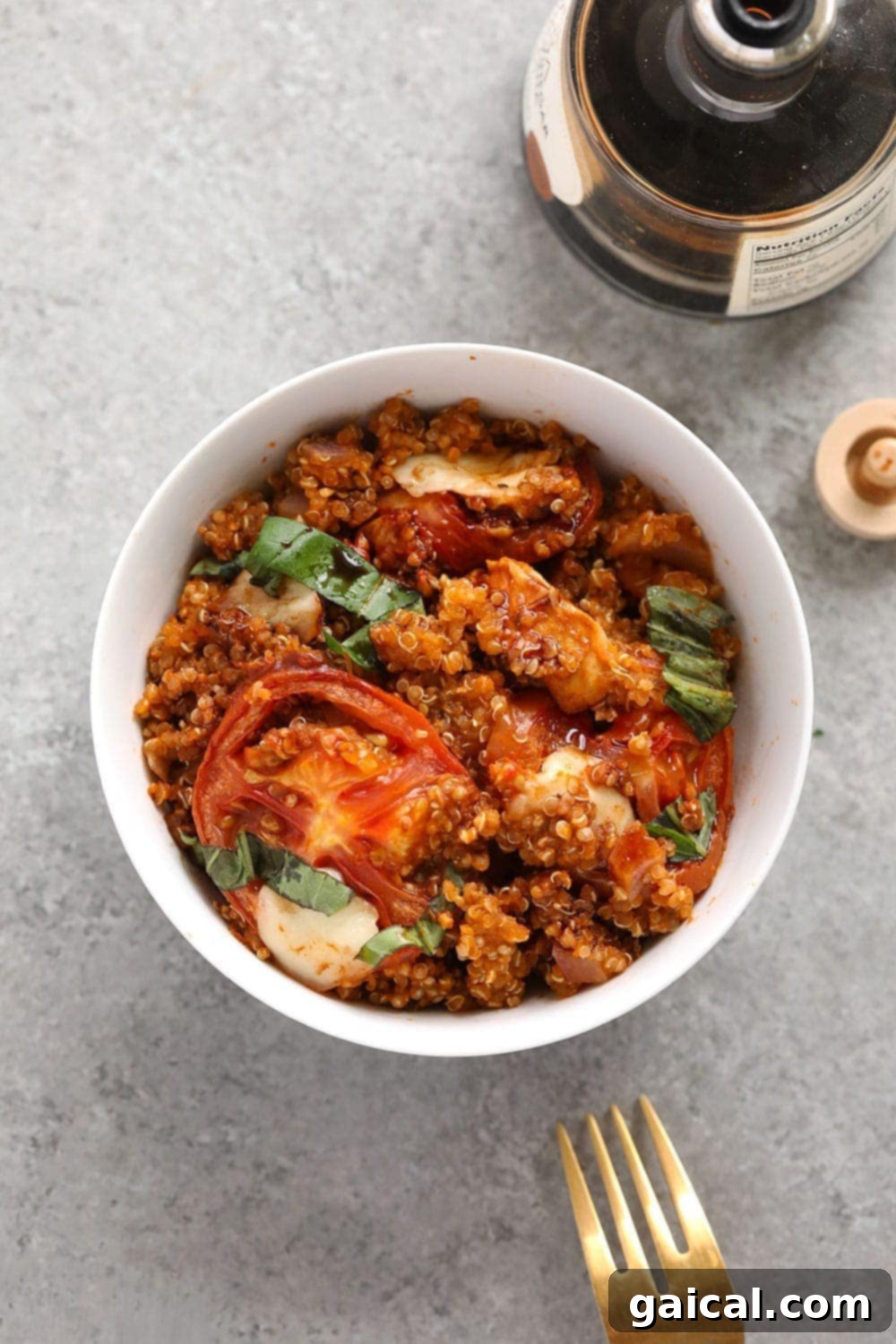 A serving of Tuscan chicken quinoa casserole in a white bowl, showing the rich blend of quinoa, chicken, and melted cheese, perfect for a hearty meal.