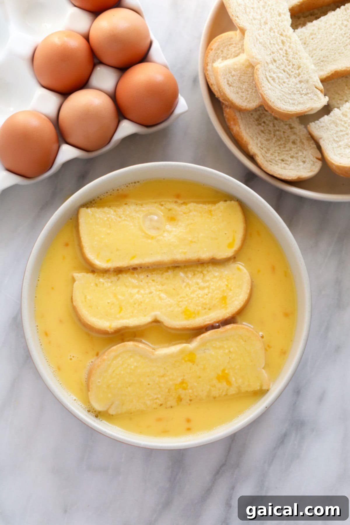 Slicing thick-cut bread into sticks and submerging them in a bowl of eggy batter for French Toast Sticks preparation.