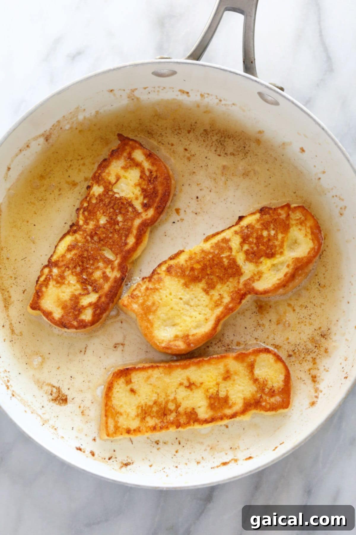Cooking French Toast Sticks in a nonstick pan until they are perfectly golden brown and crispy.
