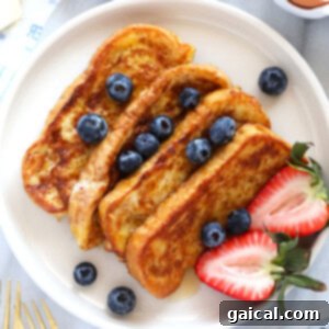 Final French toast sticks served in a small cup with maple syrup for dipping.