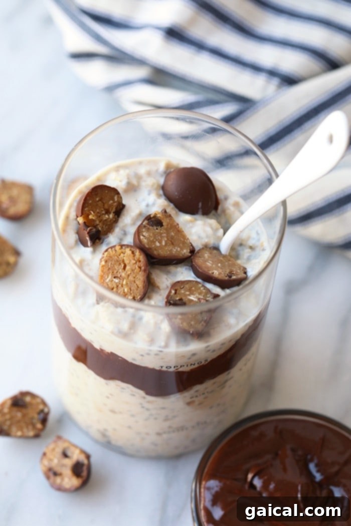 Close-up shot of creamy overnight oatmeal with generous chunks of edible cookie dough, ready to be enjoyed as a wholesome breakfast.