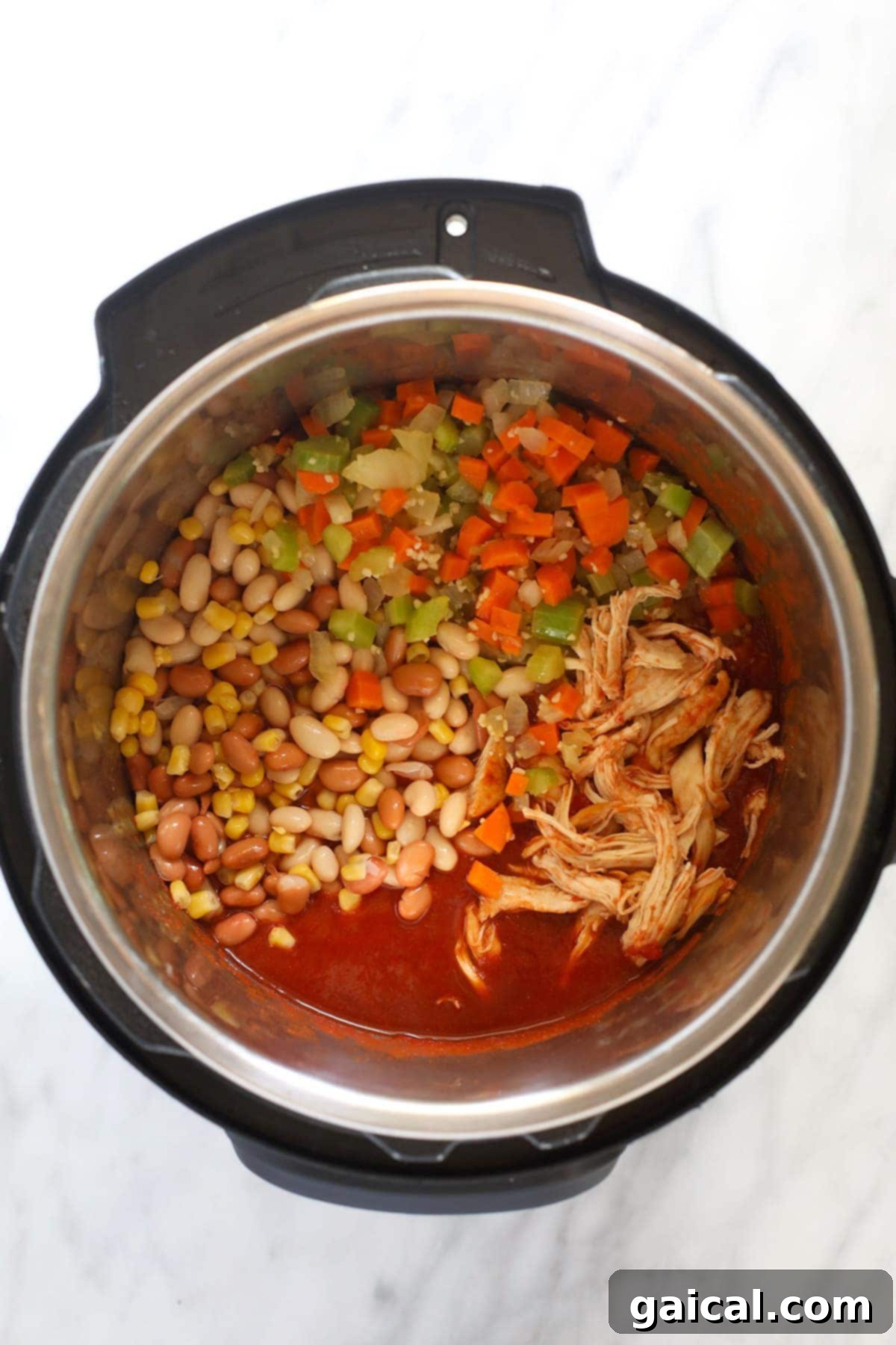 Zesty Instant Pot Buffalo Chicken Chili 5 A close-up shot of buffalo chicken chili simmering in an Instant Pot, showing the rich texture and vibrant colors of the ingredients.