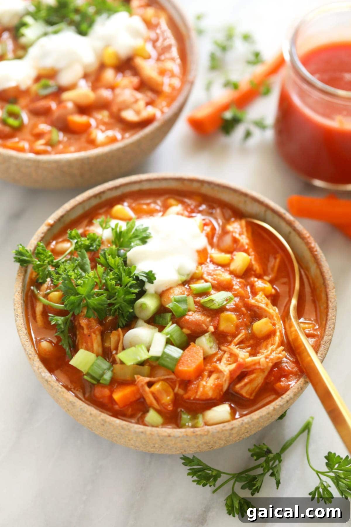 The best buffalo chicken chili recipe on the internet made in your Instant Pot! This buffalo chicken chili is flavorful, packed with veggies, and spicy just...just the way you like it! A bowl of rich buffalo chicken chili, served and garnished, showcasing its inviting texture and warmth.