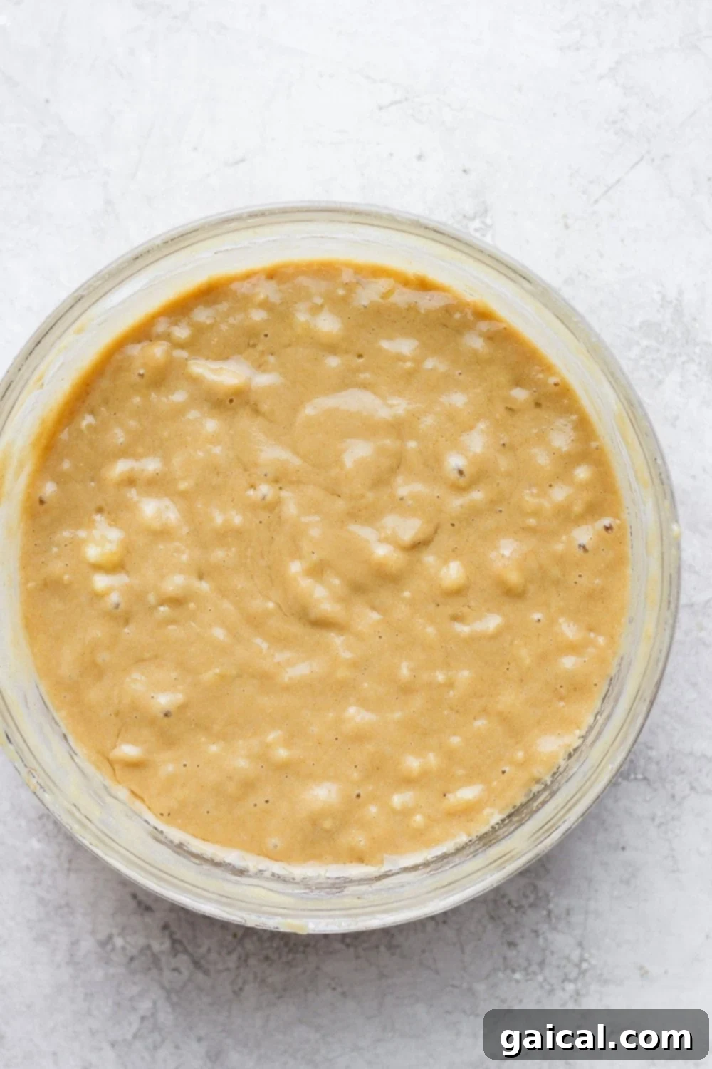 The best ever healthy banana bread recipe made with real food and just a few staple ingredients! Close-up of healthy banana bread batter in a mixing bowl, ready for the pan.
