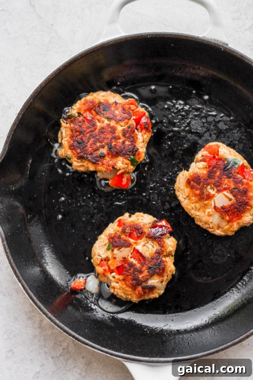 Make this salmon patties recipe with flaked salmon, veggies, fresh herbs, and a little mayo! salmon patties pan frying in a skillet