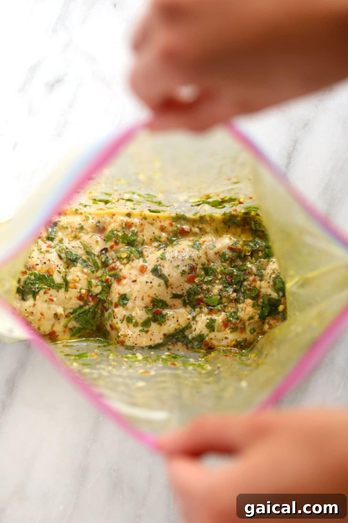 Freezing marinated chicken is an ideal solution for convenient and quick meal preparation. Raw chicken breasts generously coated in Italian marinade within a sealed, freezer-safe plastic bag, laid flat for efficient freezing.