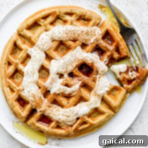 Waffled Cinnamon Rolls 7 A perfectly cooked cinnamon roll waffle on a white plate, showcasing its golden-brown texture and ready for a delicious drizzle of frosting.