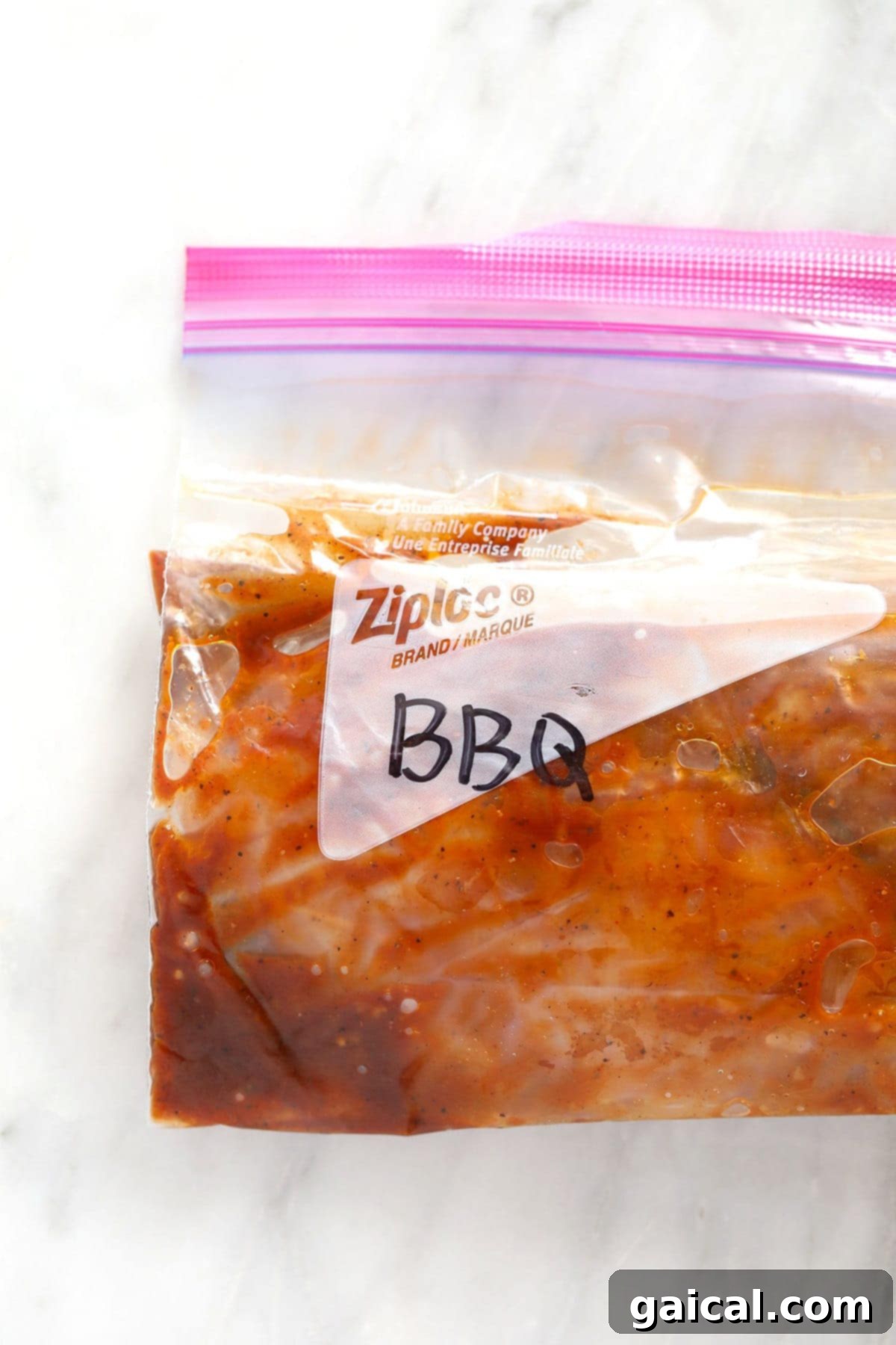 BBQ chicken marinating in a ziploc bag, clearly showing the chicken submerged in the sauce.