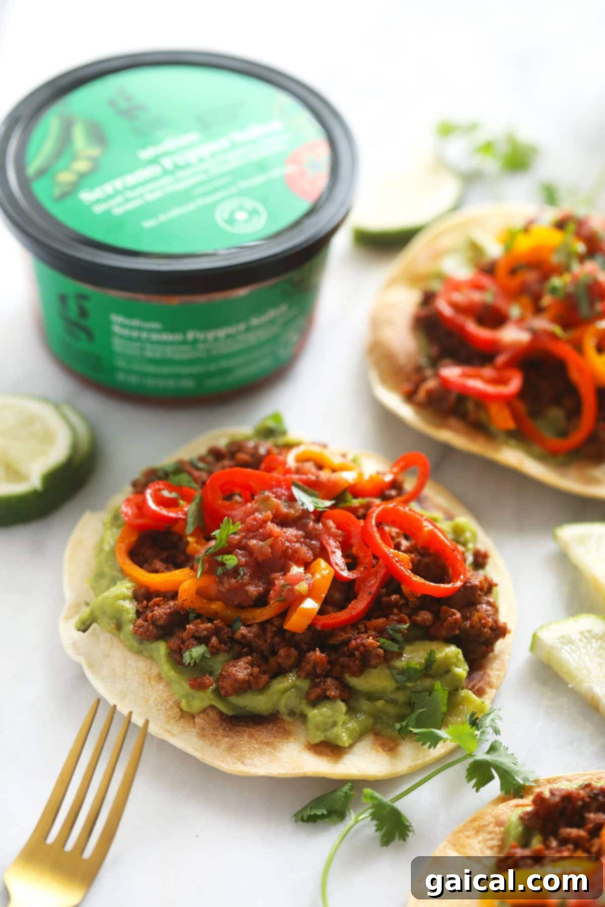 Delectable Vegetarian Tostadas with Good & Gather Ingredients Crispy vegetarian tostada topped with vibrant green guacamole, savory plant-based ground, and colorful mini sweet peppers, garnished with fresh lime.
