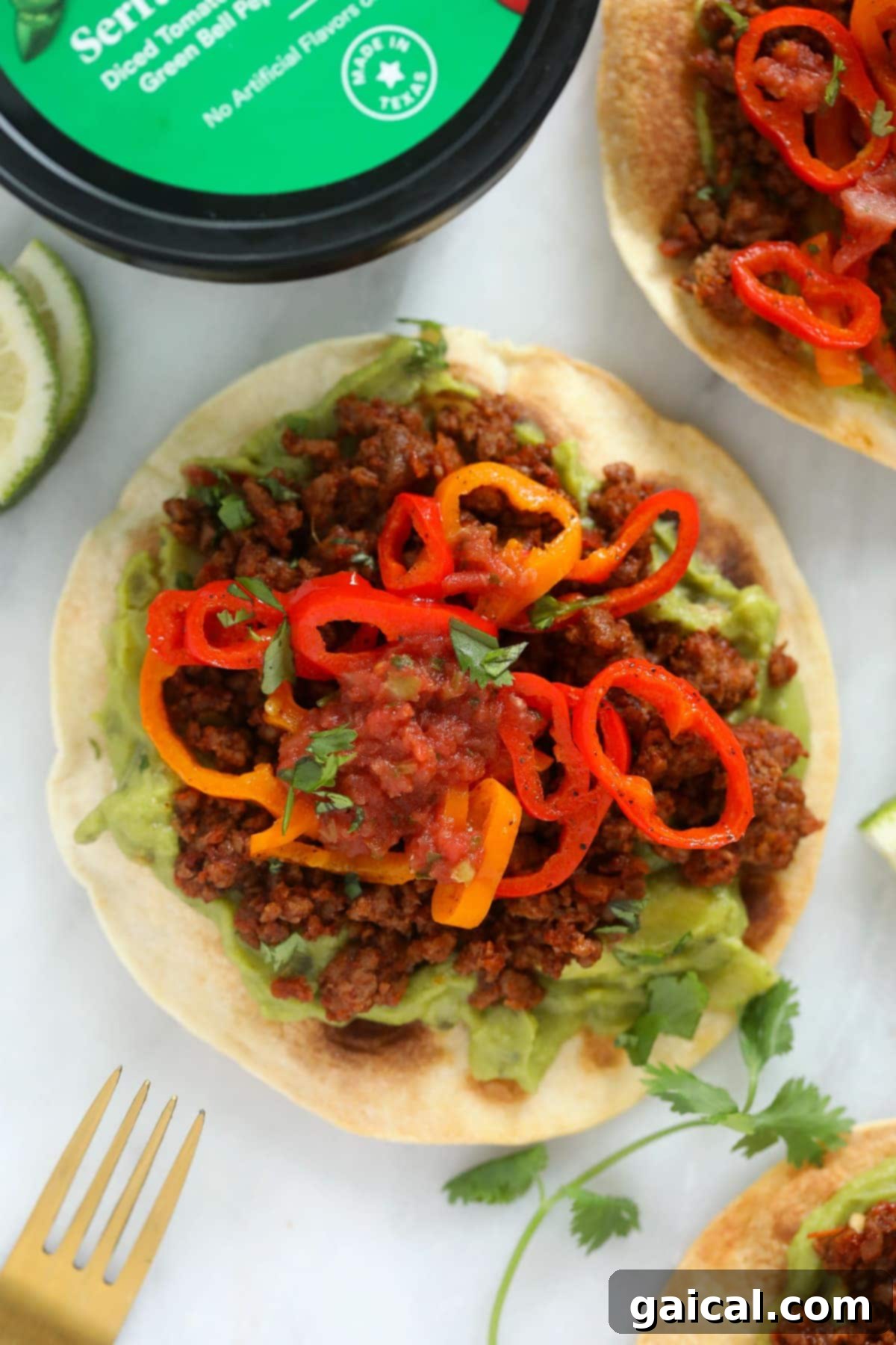 Complete Vegetarian Tostada Meal A vibrant and fully loaded tostada featuring creamy guacamole, savory plant-based ground, colorful peppers, and a drizzle of salsa, representing a perfect vegetarian meal.