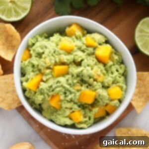 A top-down view of a bowl of mango guacamole, showcasing its fresh ingredients and vibrant colors, ready to be served.