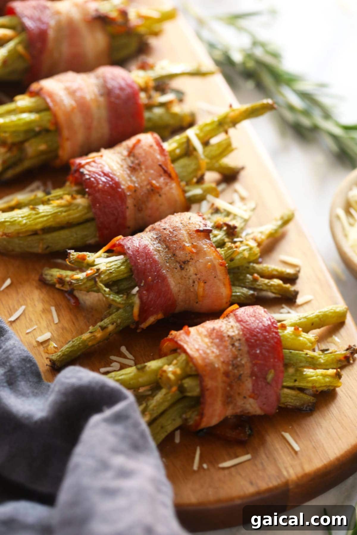 Delicious Bacon Wrapped Green Beans for Holidays and Parties Crispy bacon wrapped green beans, perfectly cooked and ready to be served on a platter, garnished with fresh herbs.