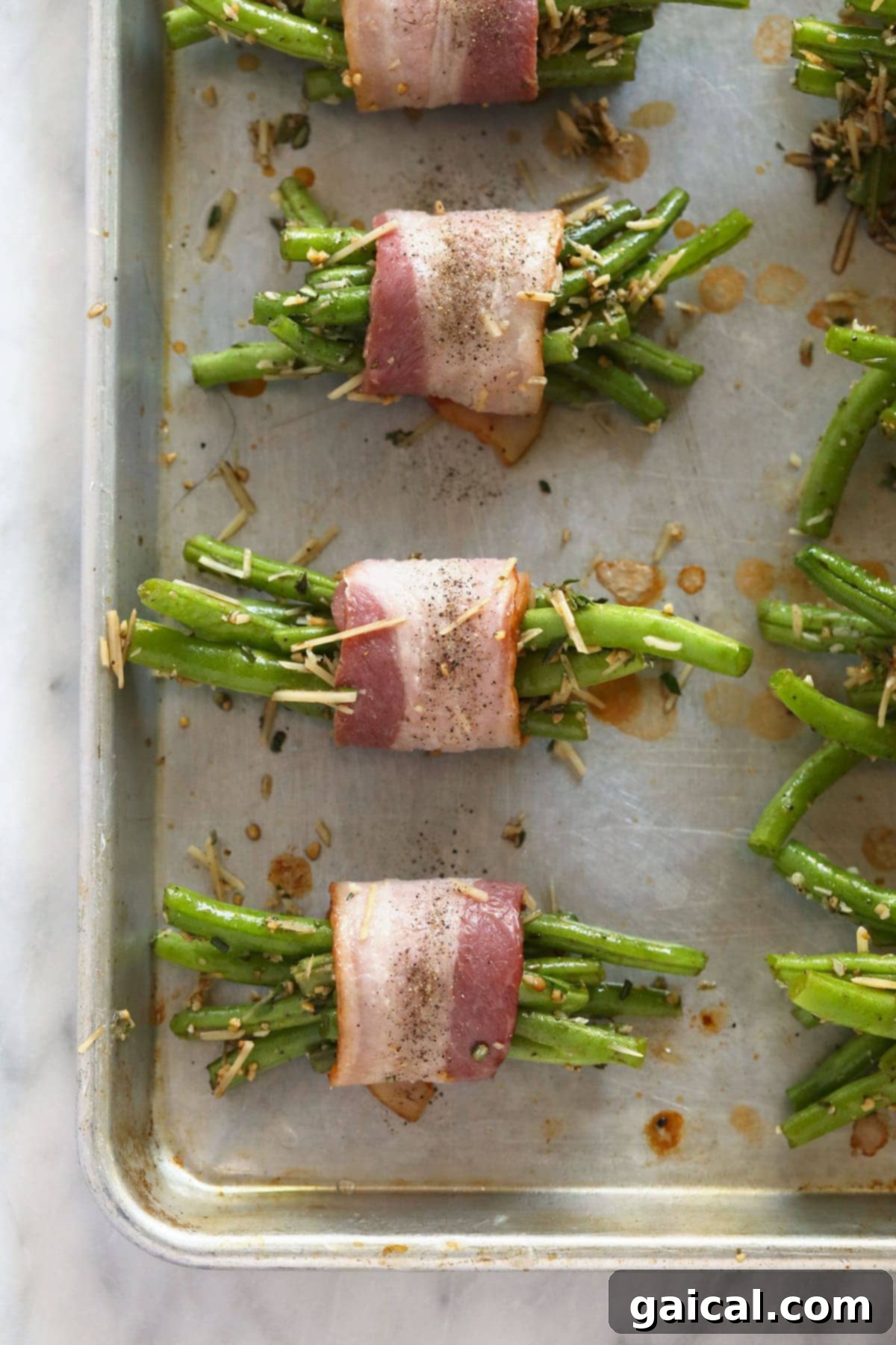 Green Bean Bundles Prepped for Baking Partially cooked bacon wrapped around bundles of fresh green beans, seasoned and arranged neatly on a baking sheet, ready to be baked to perfection.