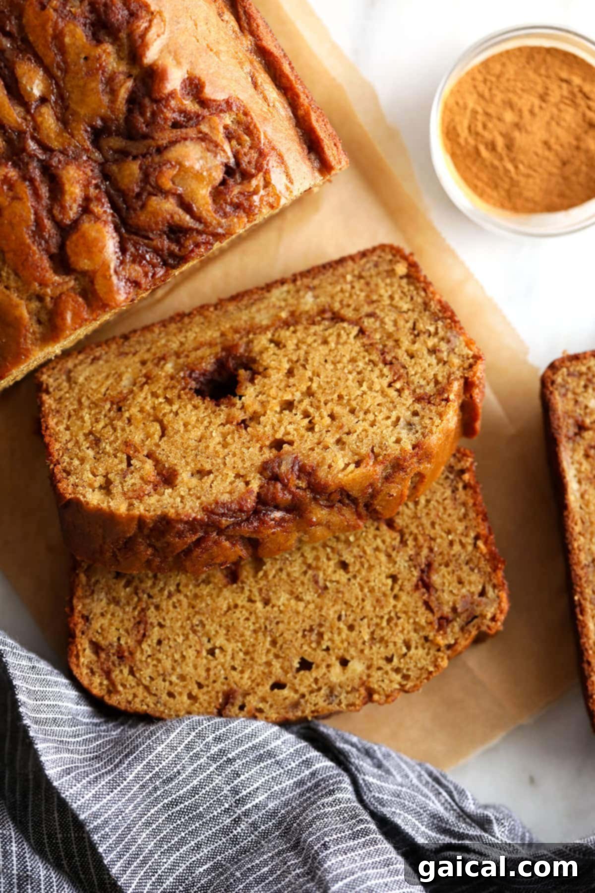 Heavenly Cinnamon Swirl Banana Bread 2 A glorious slice of cinnamon swirl banana bread resting on a rustic cutting board, showcasing its beautiful, defined cinnamon ribbon.