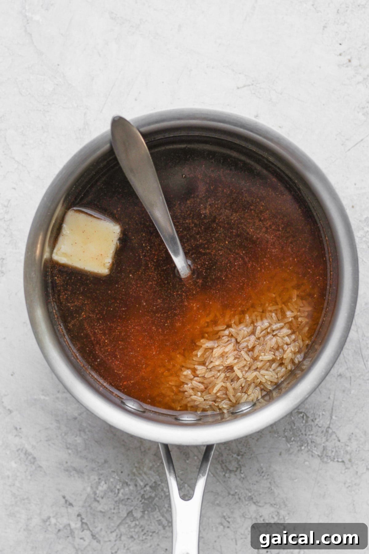 Brown rice and rich beef broth, preparing to be cooked in a large stock pot