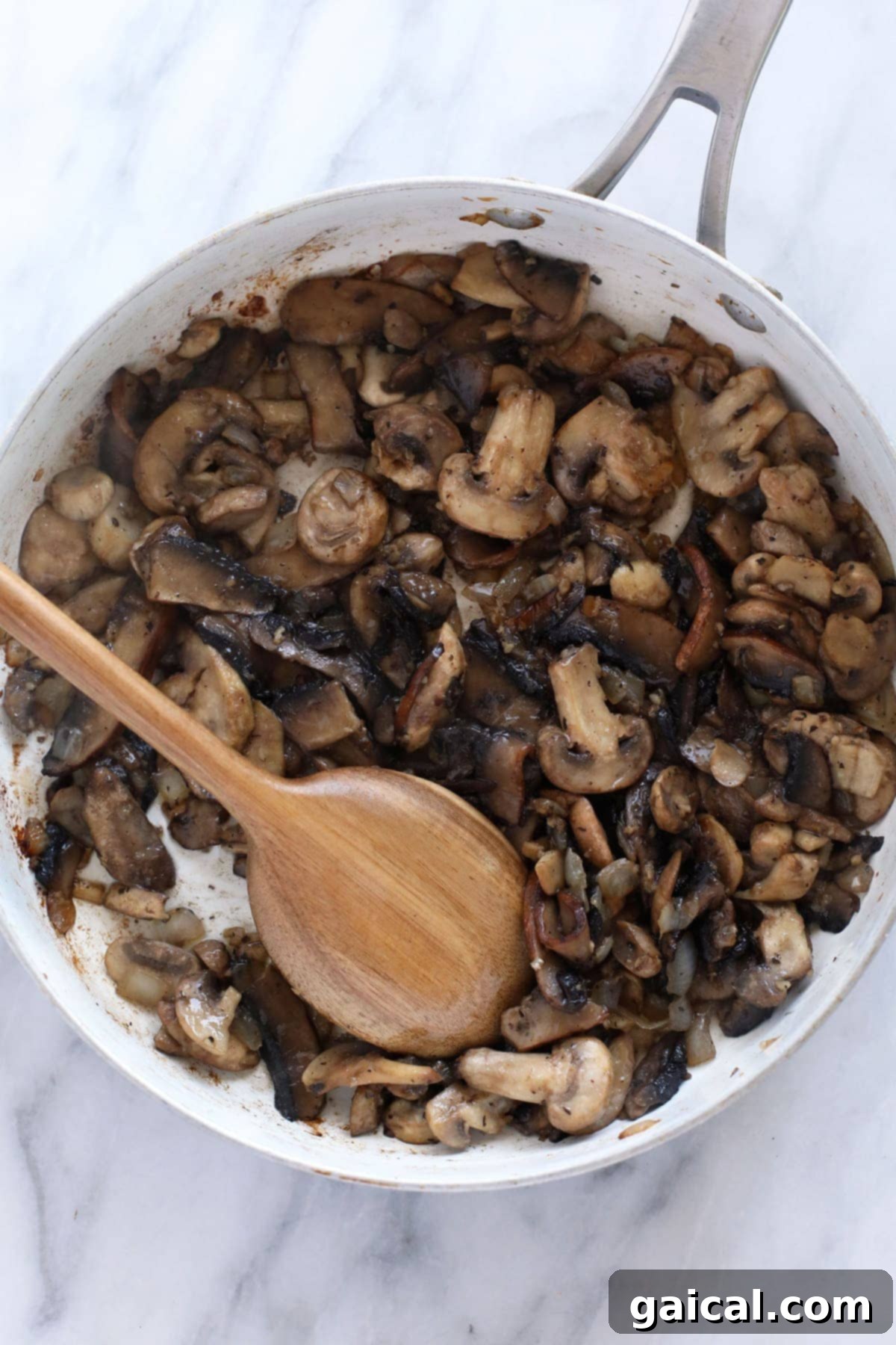Creamy Mushroom Stroganoff 4 A vibrant close-up of mixed mushrooms achieving a perfect golden-brown sear in a large stainless steel frying pan, indicating readiness for the next steps of the stroganoff sauce preparation.