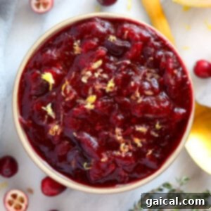 Unique cranberry sauce recipe served in a bowl with lemon and thyme.