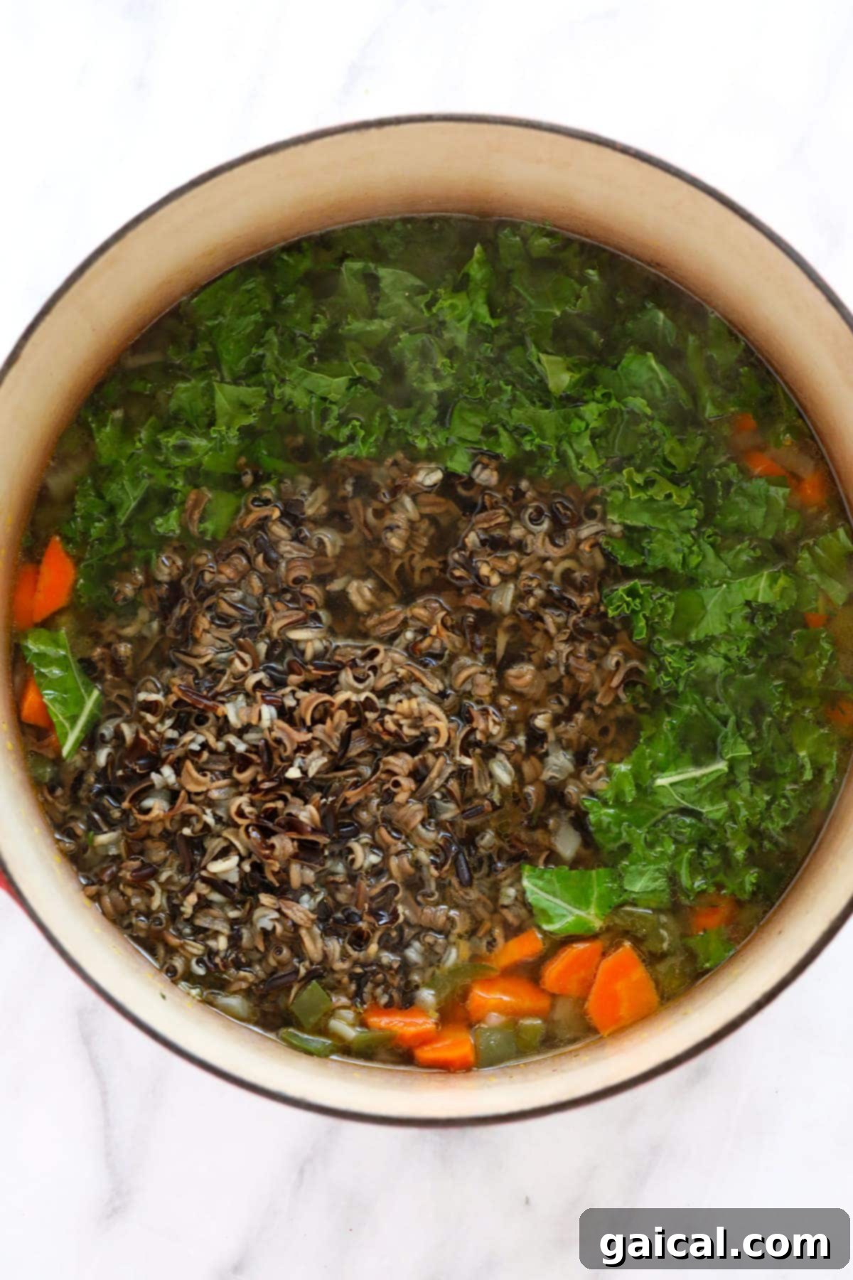 Hearty Chicken Wild Rice Soup 5 Ingredients for chicken wild rice soup simmering in a large stock pot with chicken broth.