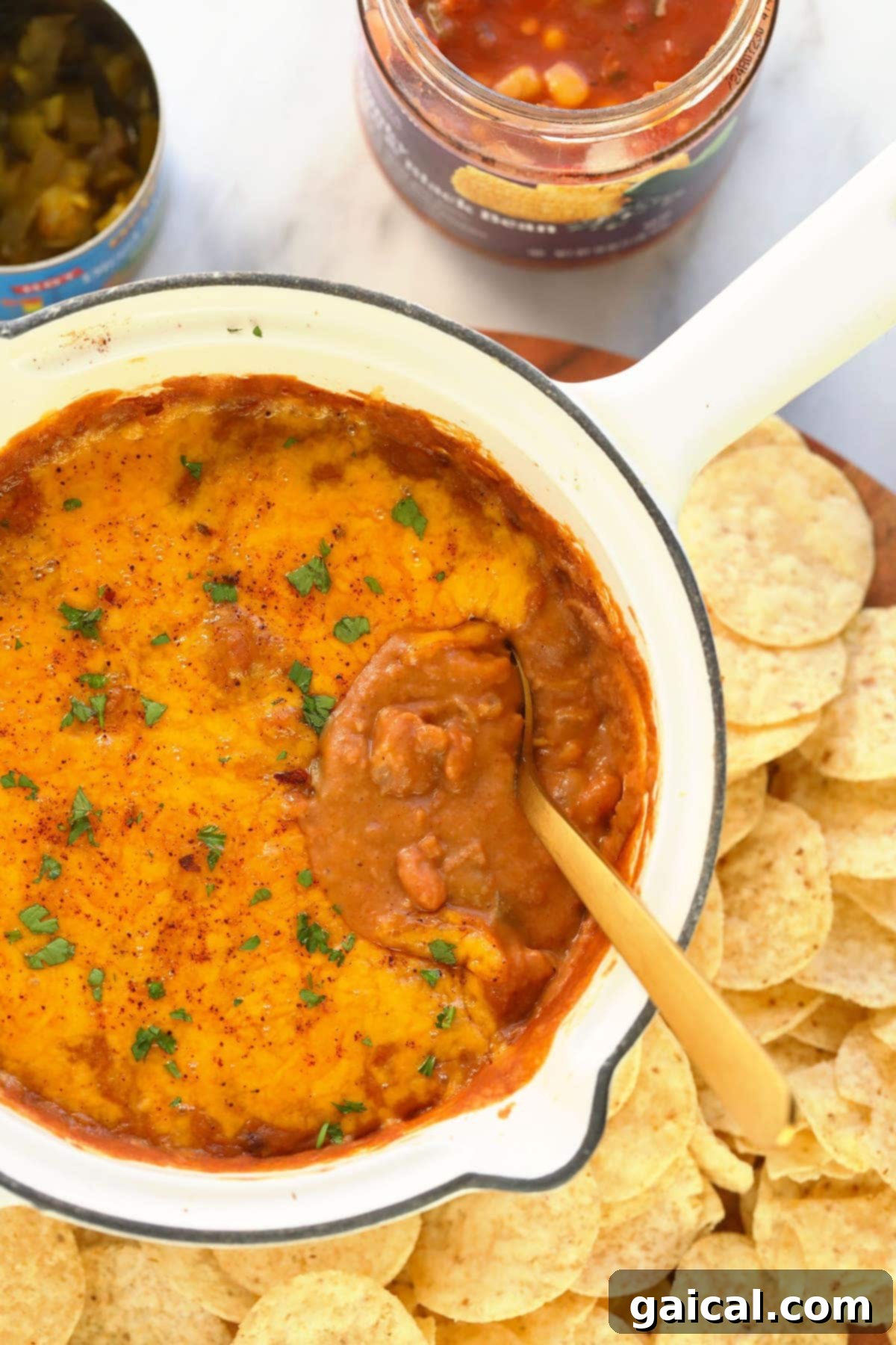 The finished bean dip, bubbling with golden melted cheese, straight out of the oven. bean dip covered in melted cheese and baked to perfection