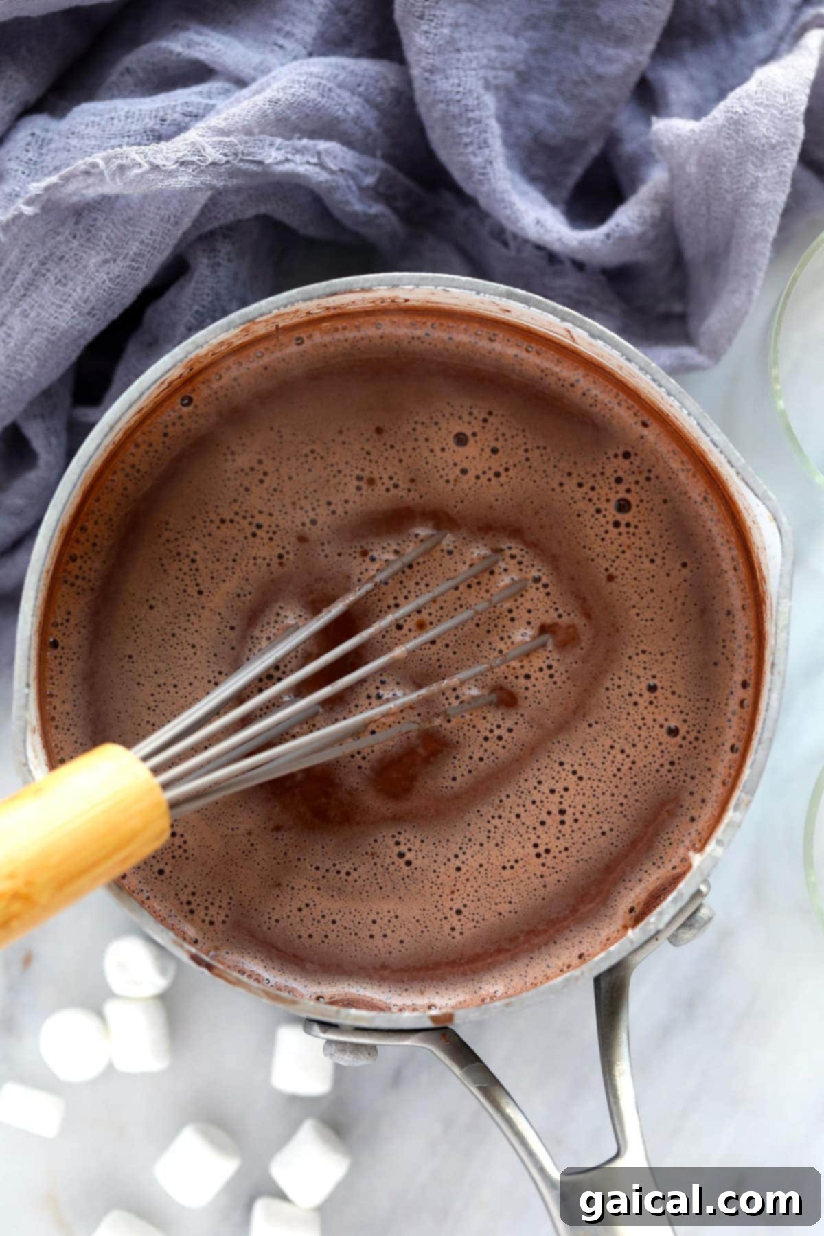 Whisking Spiked Hot Chocolate in a Saucepan A saucepan of rich, dark spiked hot chocolate being whisked, showcasing the smooth, creamy texture as it heats on the stove.