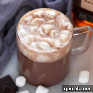 A top-down view of a mug of easy spiked hot chocolate topped with mini marshmallows.