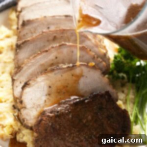 Melt-Away Slow Cooker Pork Loin 2 slow cooker pork loin sliced on a bed of mashed potatoes, ready to be served.