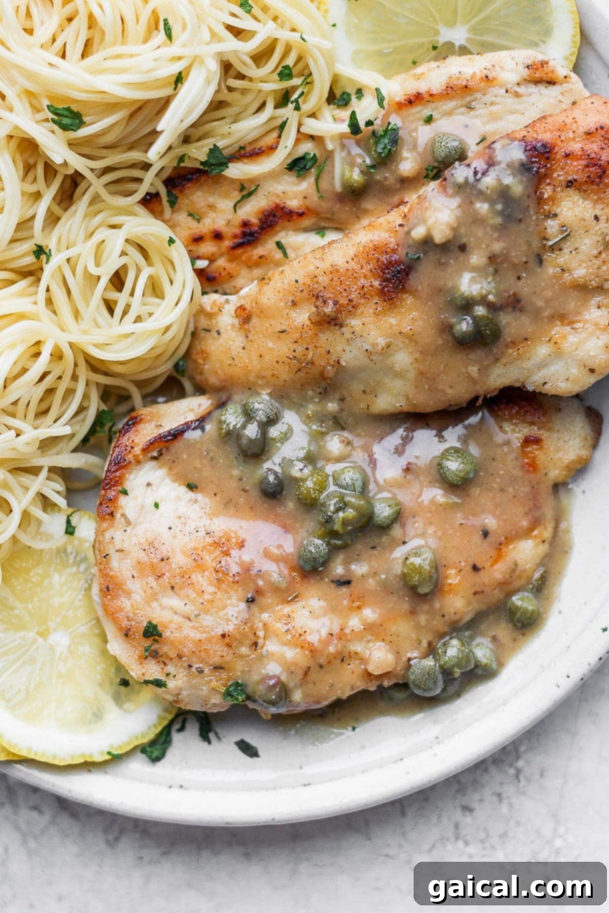 Plated chicken piccata served with capers and fresh herbs, ready to be enjoyed.