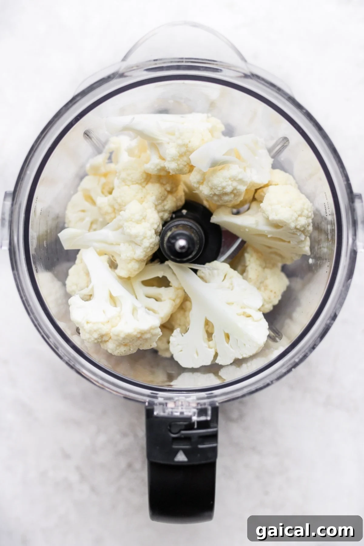 Cauliflower Grains 3 Raw florets of cauliflower being pulsed in a food processor.