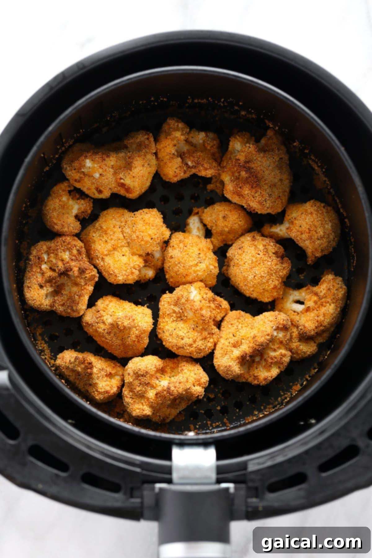 Close-up of golden brown, crunchy cauliflower florets fresh out of the air fryer.
