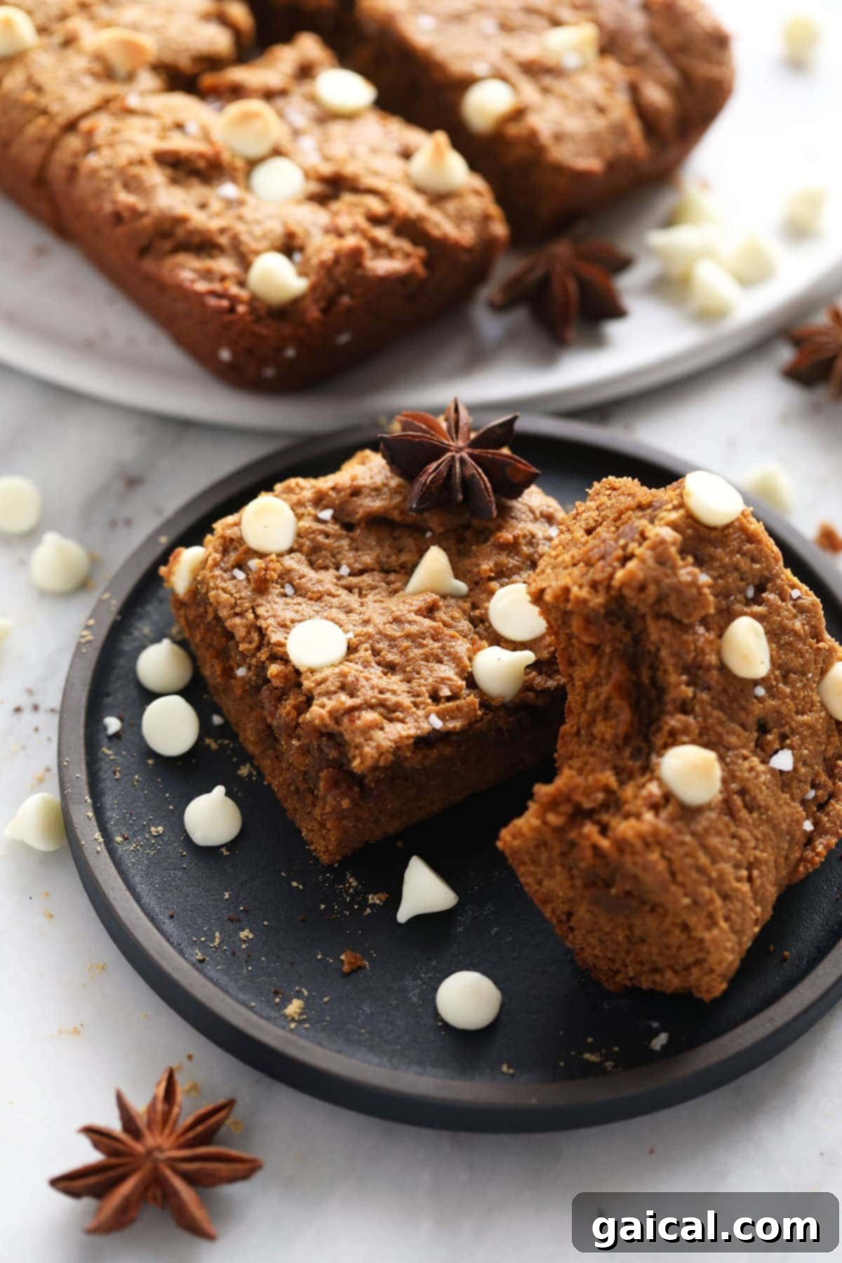 Spiced Gingerbread Bars 2 Deliciously chewy gingerbread cookie bars topped with white chocolate chips, ready to be enjoyed as a festive sweet treat.
