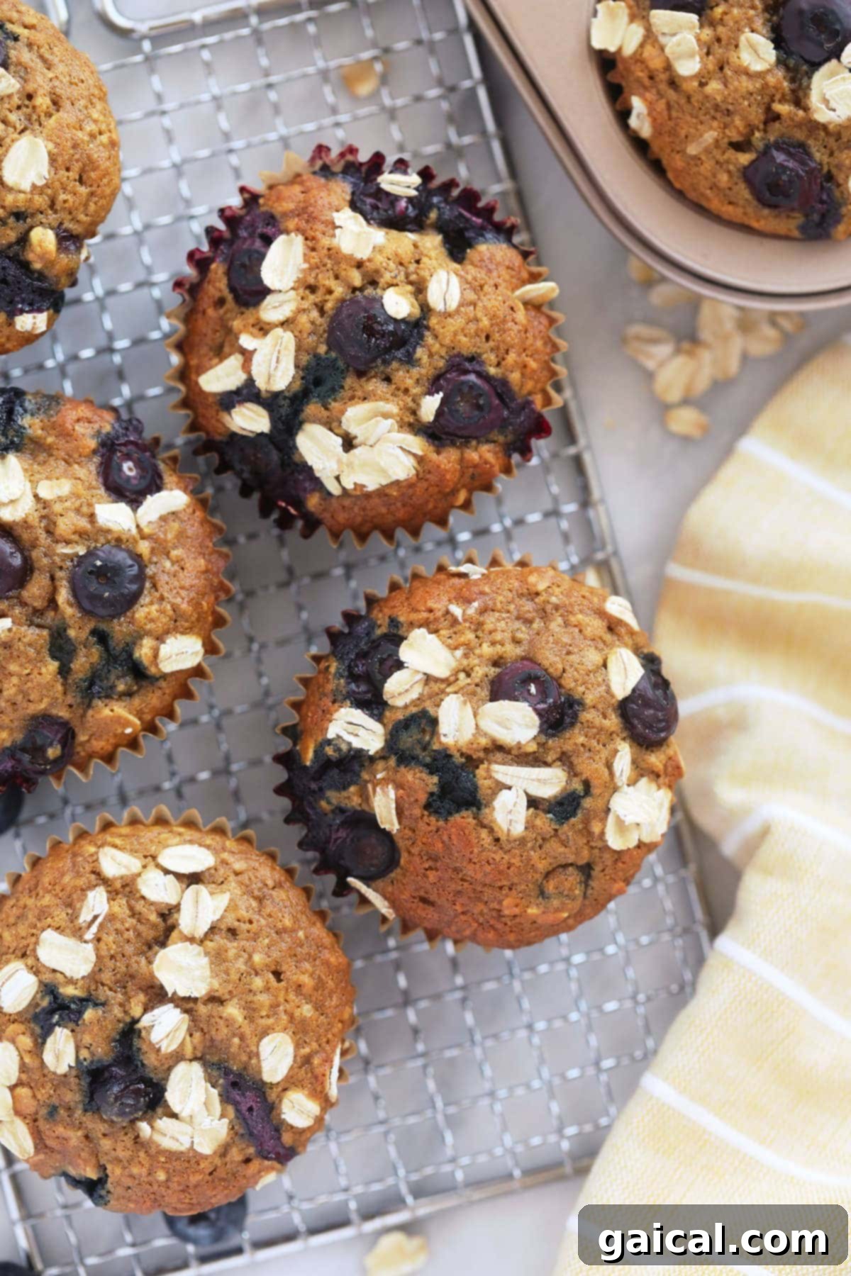 Freshly baked blueberry oatmeal muffins arranged on a cooling rack, looking perfectly golden and fluffy.