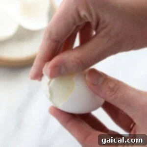 En person som skreller et hardkokt egg.