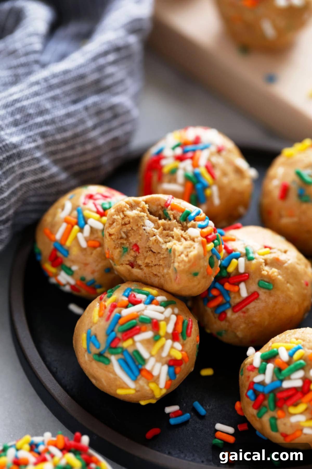 Enjoying a Cake Batter Protein Ball A delicious cake batter protein ball with a bite taken out, revealing its soft interior and colorful sprinkles.