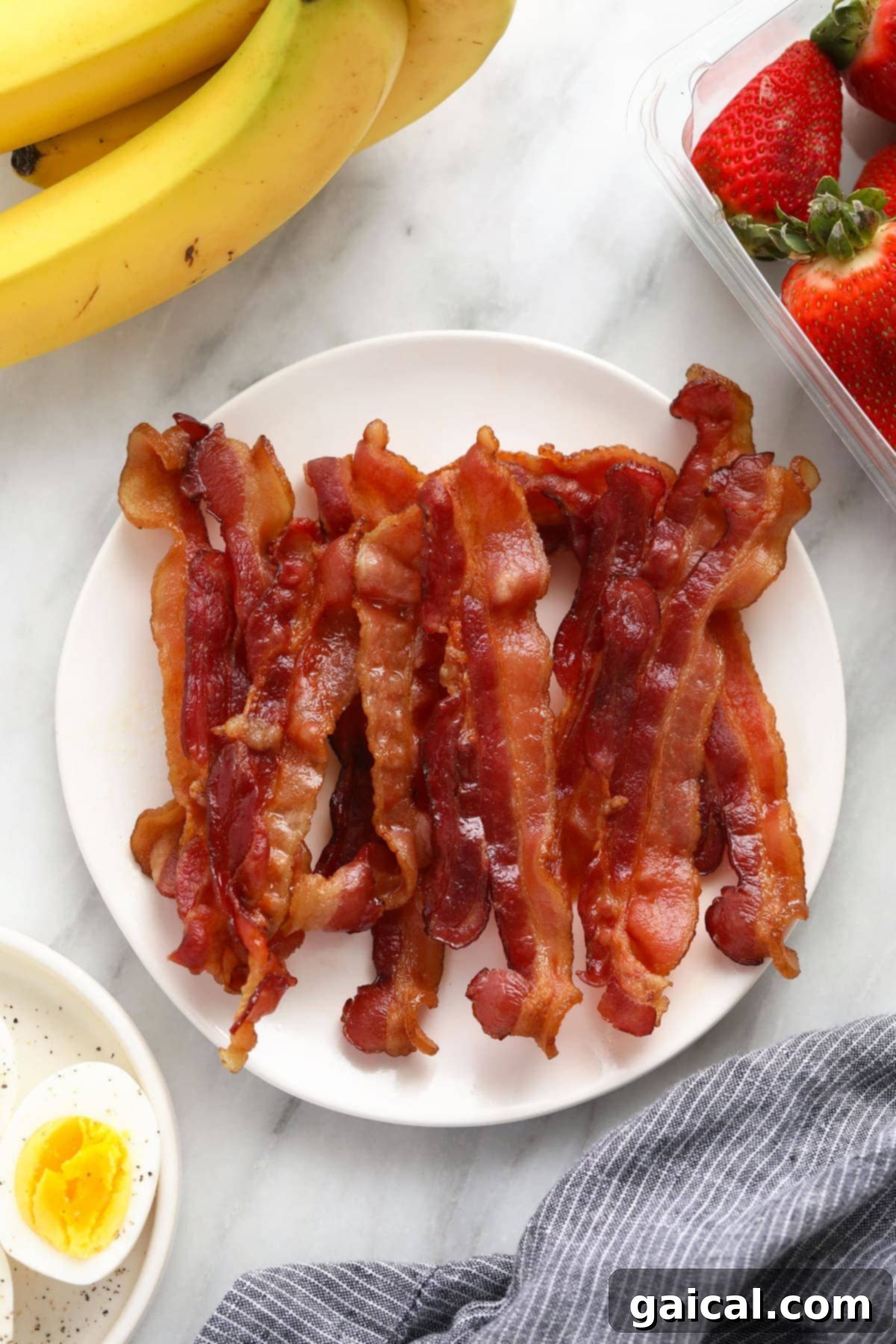 Effortless Microwave Bacon Crispy microwave bacon slices on a plate with paper towel, perfectly cooked.
