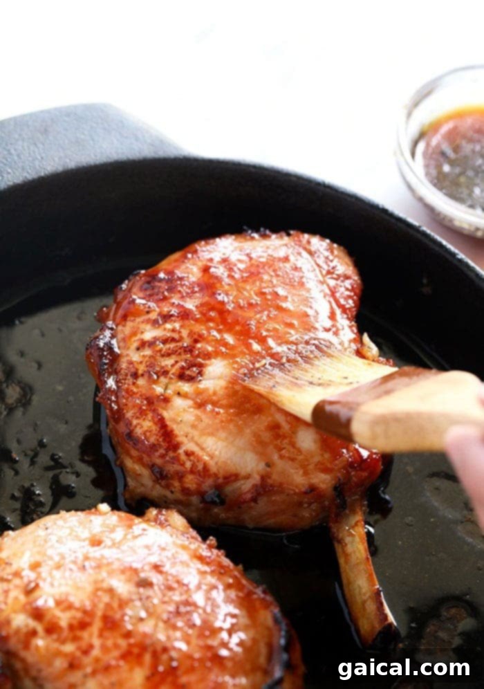 Luscious Honey Sticky Pork and 20 More Pork Recipes 4 A perfectly cooked bone-in pork chop, golden brown and garnished with fresh herbs.