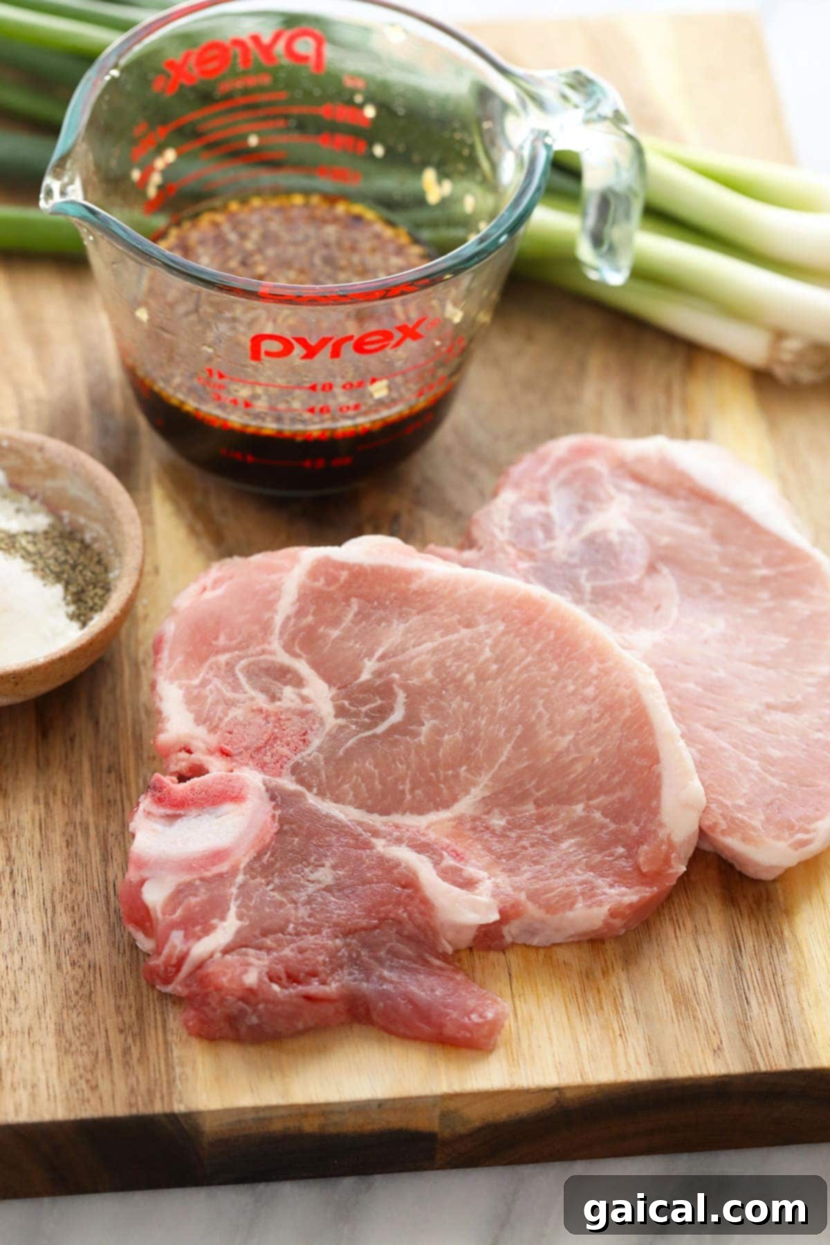 Fresh Boneless Pork Chops for Sticky Honey Pork Boneless pork chops on a cutting board, prepped for slicing.
