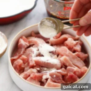 Luscious Honey Sticky Pork and 20 More Pork Recipes 6 Pork strips being coated with cornstarch mixture.