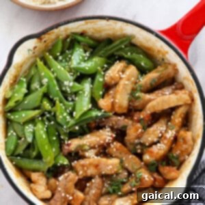 Luscious Honey Sticky Pork and 20 More Pork Recipes 8 Cooked sticky honey pork in a skillet with green onions and sesame seeds.