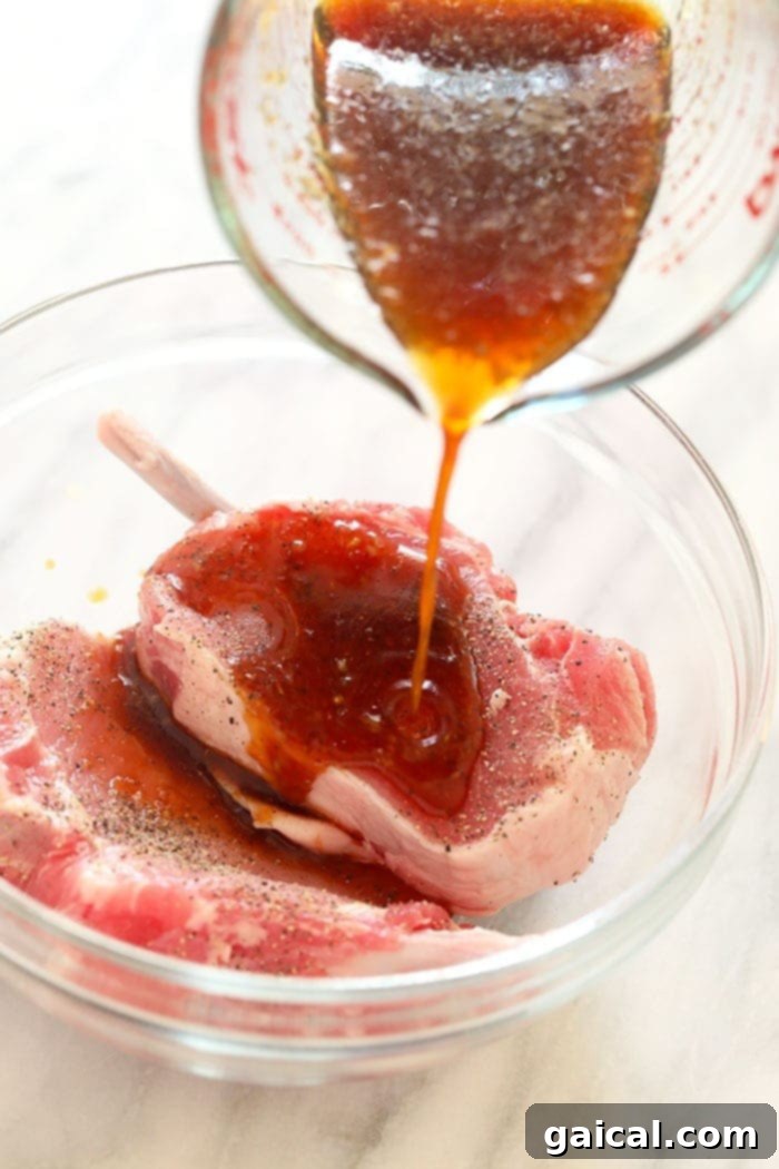 Marinating Pork Chops for Enhanced Flavor Bone-in pork chops marinating in a flavorful liquid in a bowl, absorbing the delicious essences.