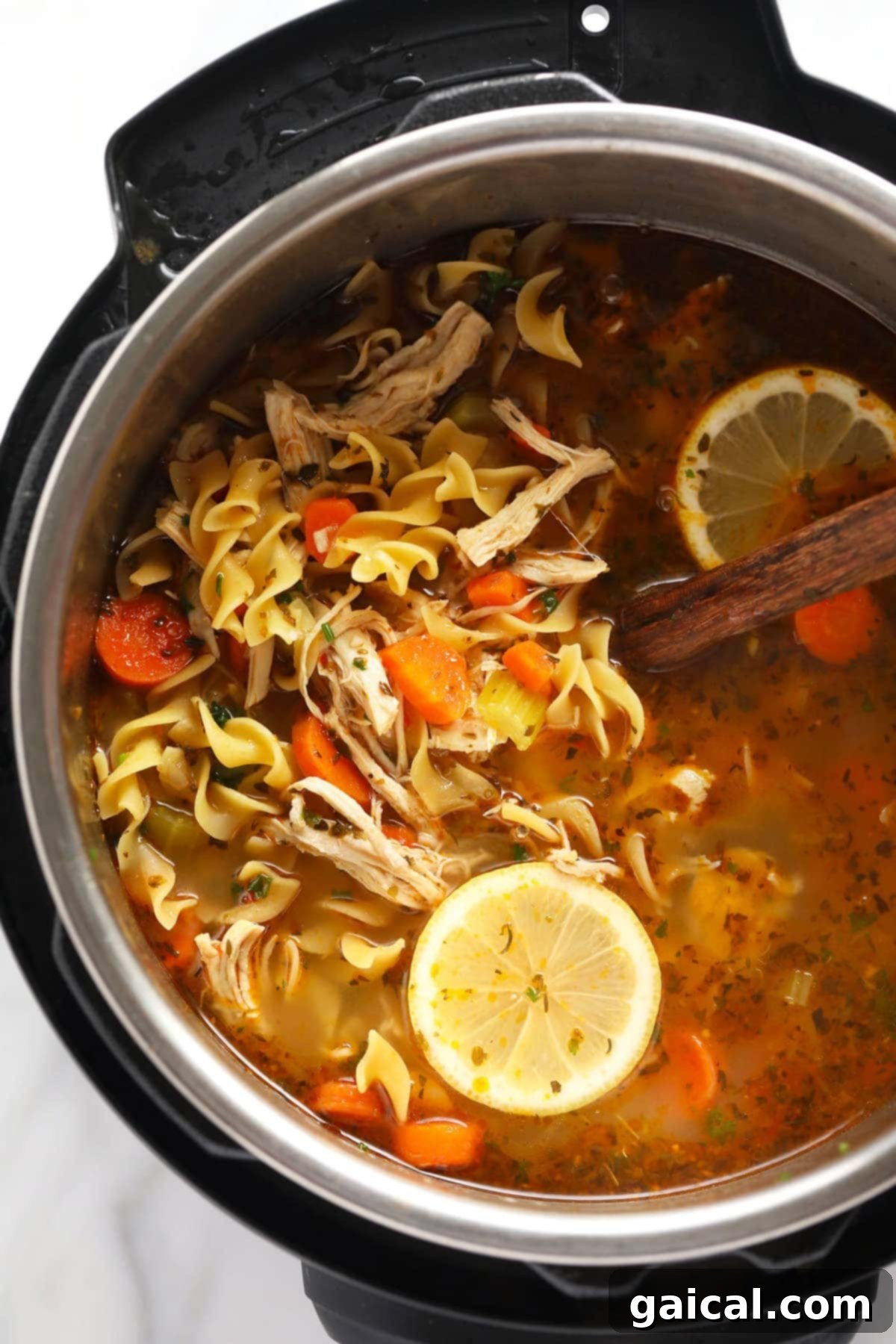 A bright and delicious Instant Pot Chicken Noodle Soup recipe that's ready in less than an hour. The broth is just delicious and it's packed with veggies! A bright and delicious Instant Pot Chicken Noodle Soup recipe that's ready in less than an hour. The broth is just delicious and it's packed with veggies! The soup is shown in the Instant Pot with lemon wedges on the side.