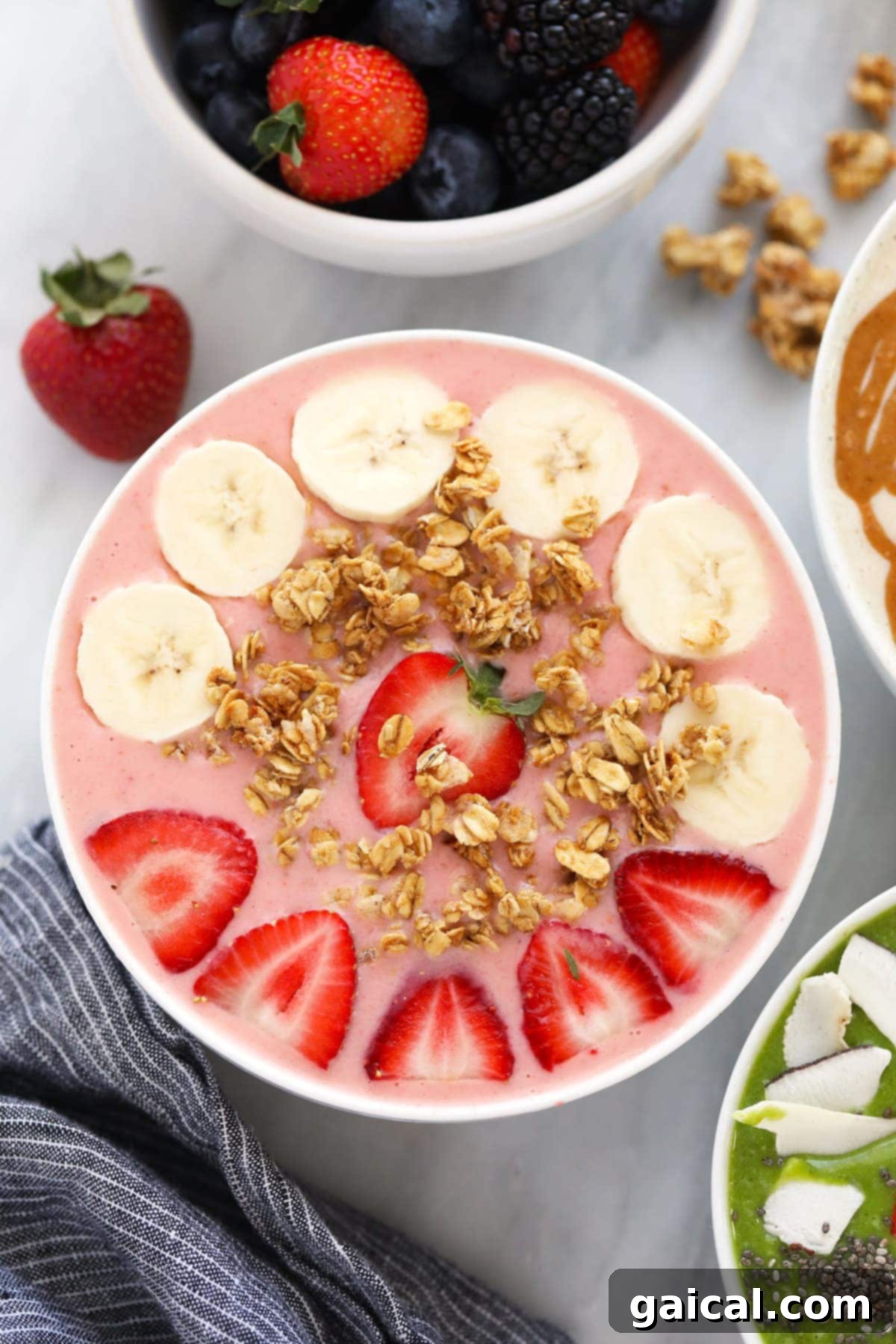 Smoothie Bowl Variations 8 A vibrant strawberry smoothie bowl garnished with fresh banana slices, crunchy granola, and whole strawberries, showcasing its natural appeal.